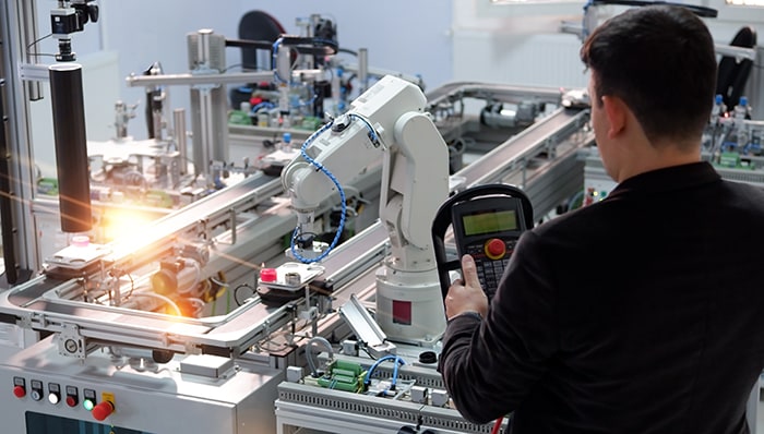 Industrial robots operate behind safety barriers